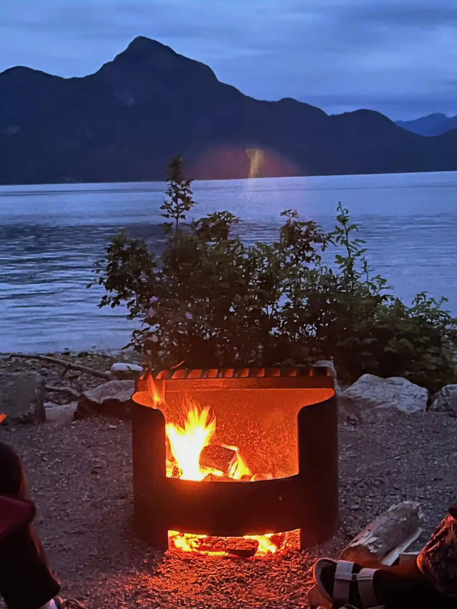 Ein Lagerfeuer vor einem Bergpanorama.