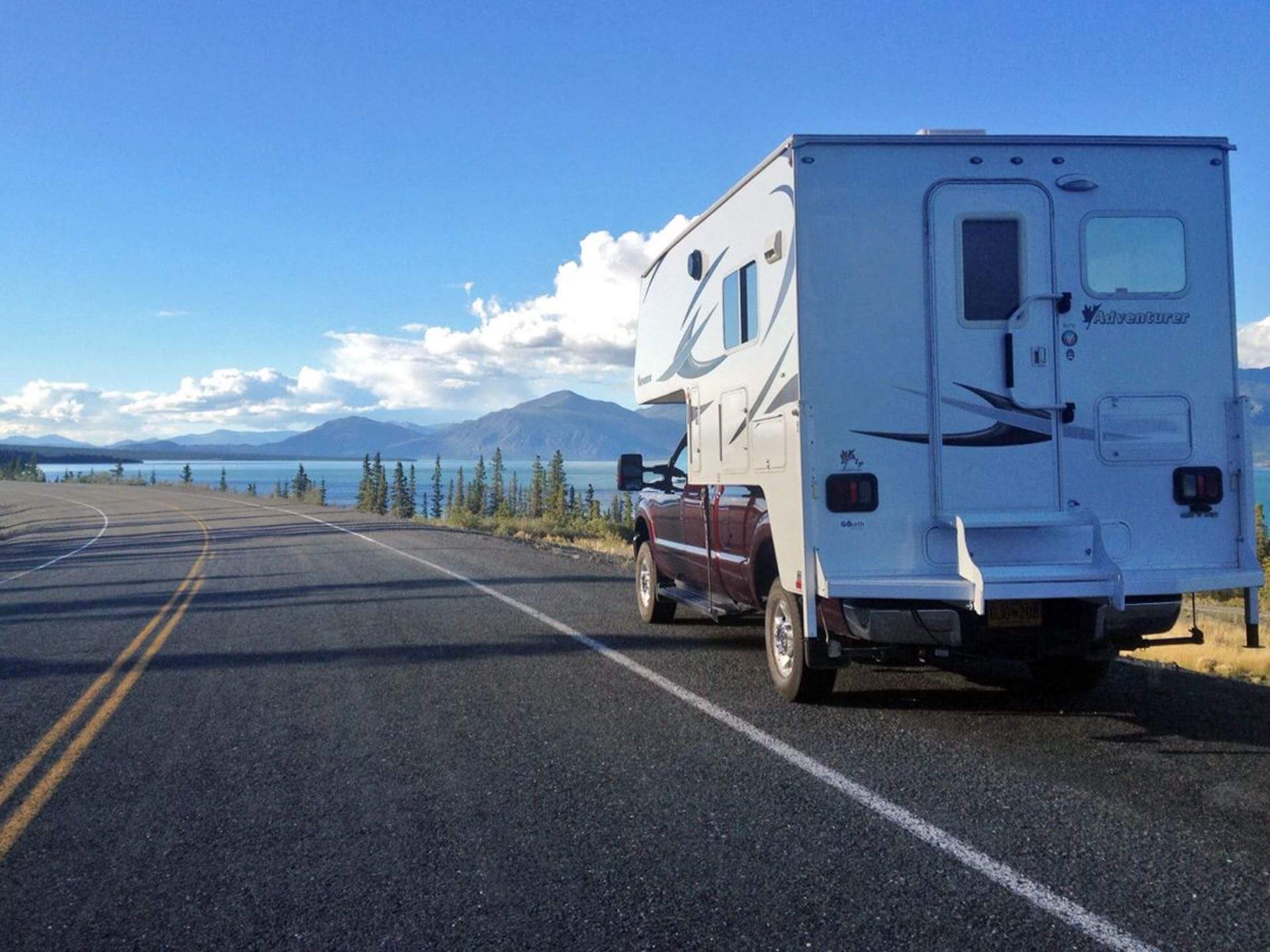 Ein Camper auf dem Alaska Highway mit Blick auf eine Berglandschaft.