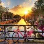 Fahrräder auf einer Brück in Amsterdam bei Sonnenaufgang