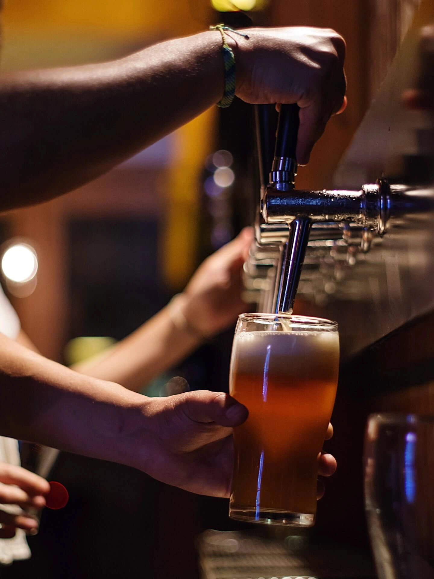 Ein Bier wird hinter der Theke gezapft