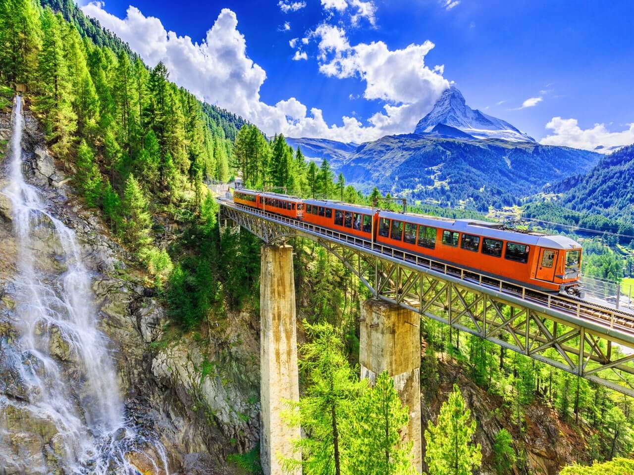 Gornergratbahn und Wasserfall in Zermatt, Schweiz.