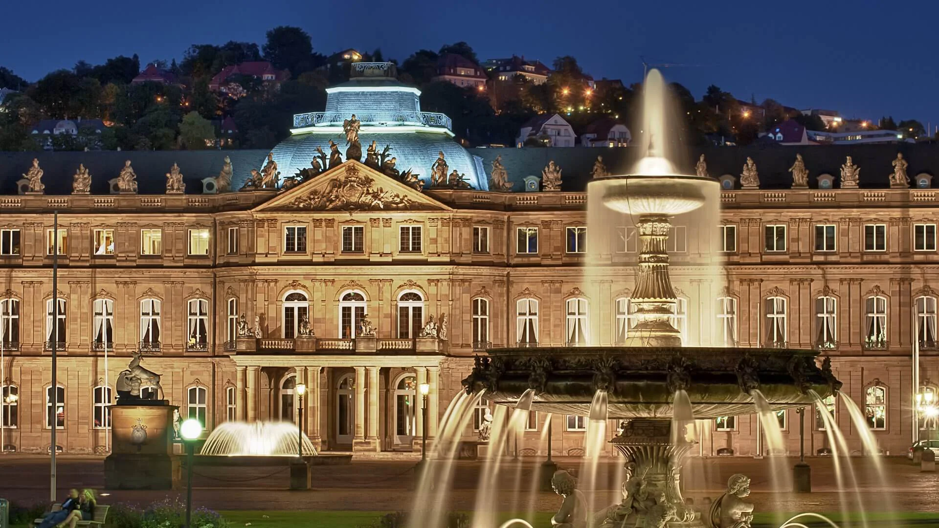 Wasserfontäne beim Springbrunnen vor dem Neuen Schloss in Stuttgart bei Nacht.