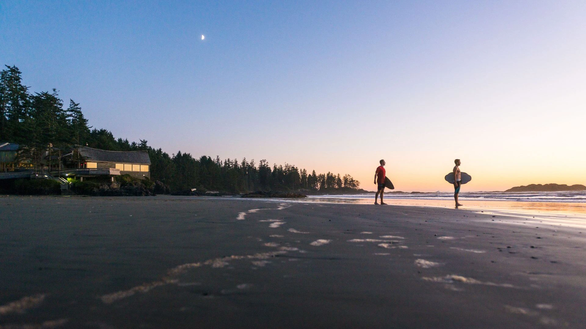 Zwei Männer mit Surfbrett am Wickaninnsh Beach im Pacific Rim Nationalpark.
