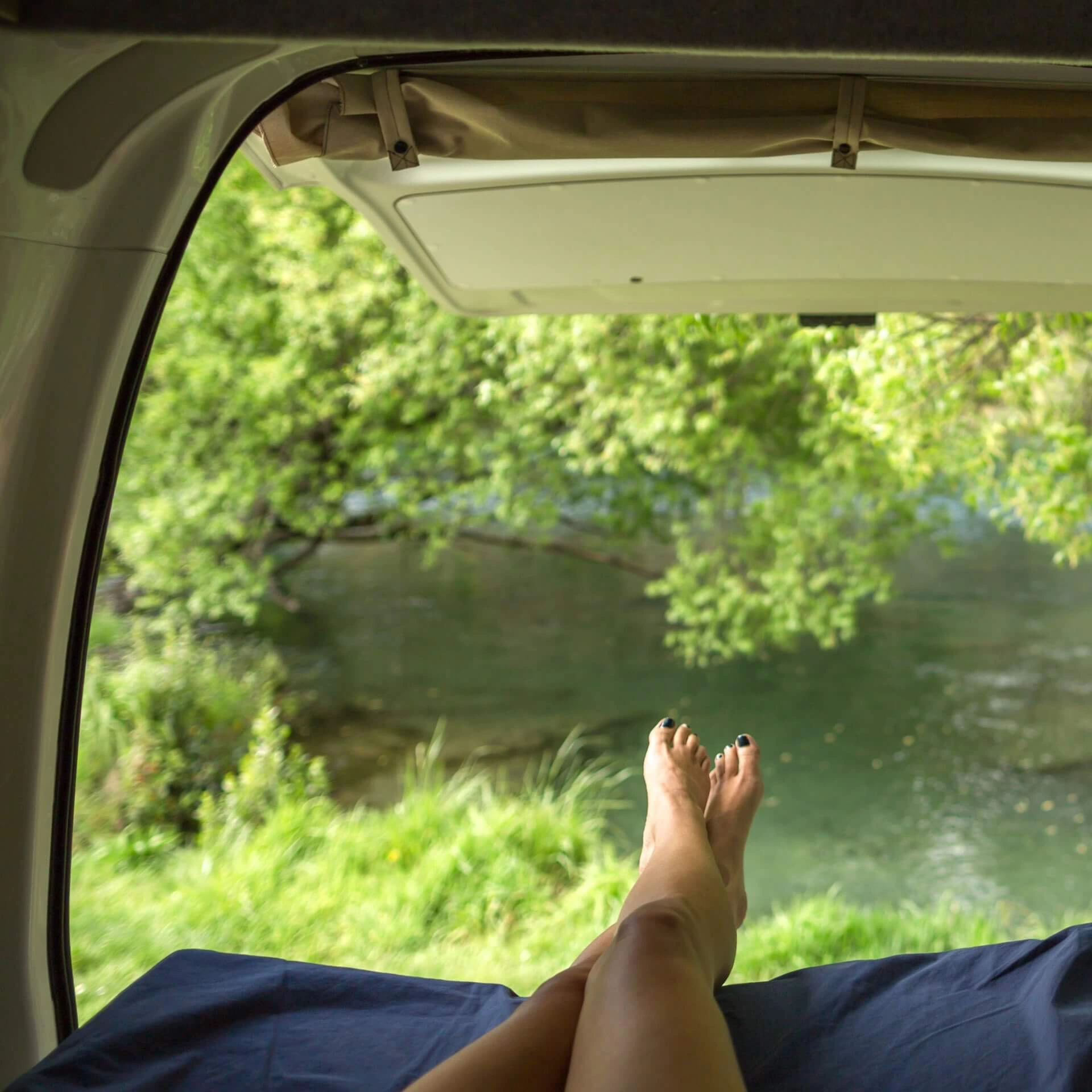 Zwei Beine ragen aus einem Campervan
