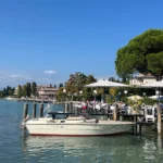 Blick auf den Garda See und seiner schönen Kulisse mit einem Restaurant auf dem Steg in Sirmione in Italien.