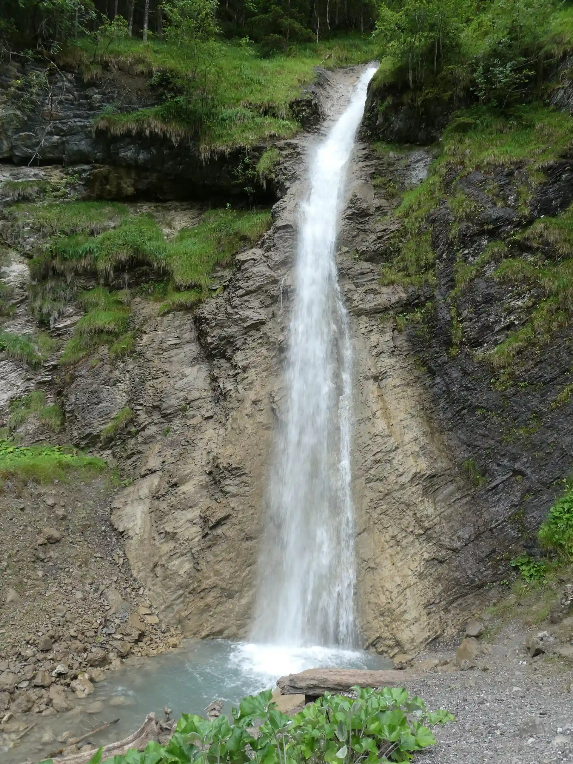 Ein Wasserfall fließt am Rande des Walderlebnispfades.