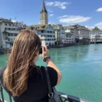 Eine Frau schießt ein Foto vom türkisfarbenen Zürichsee.
