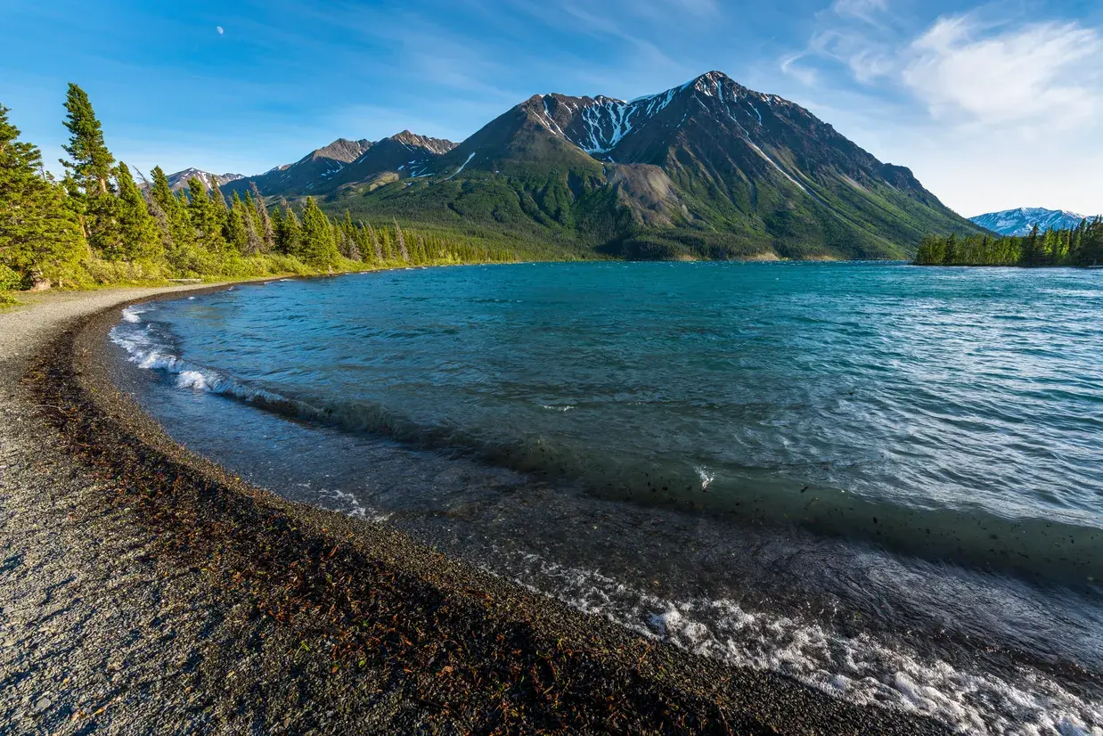 Blick über das klare, türkisblaue Wasser eines Sees im Kluane National Park.