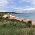 Wolken schweben über einem Strand in Nova Scotia.