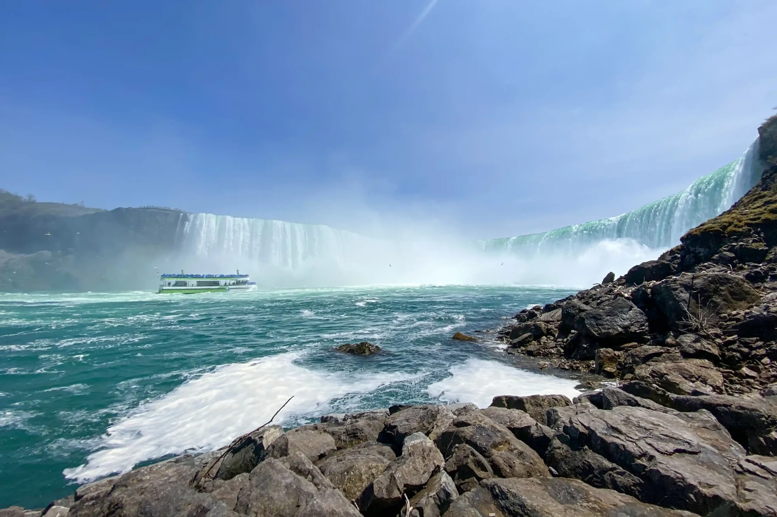 Ein Schiff fährt vor den Niagarafällen