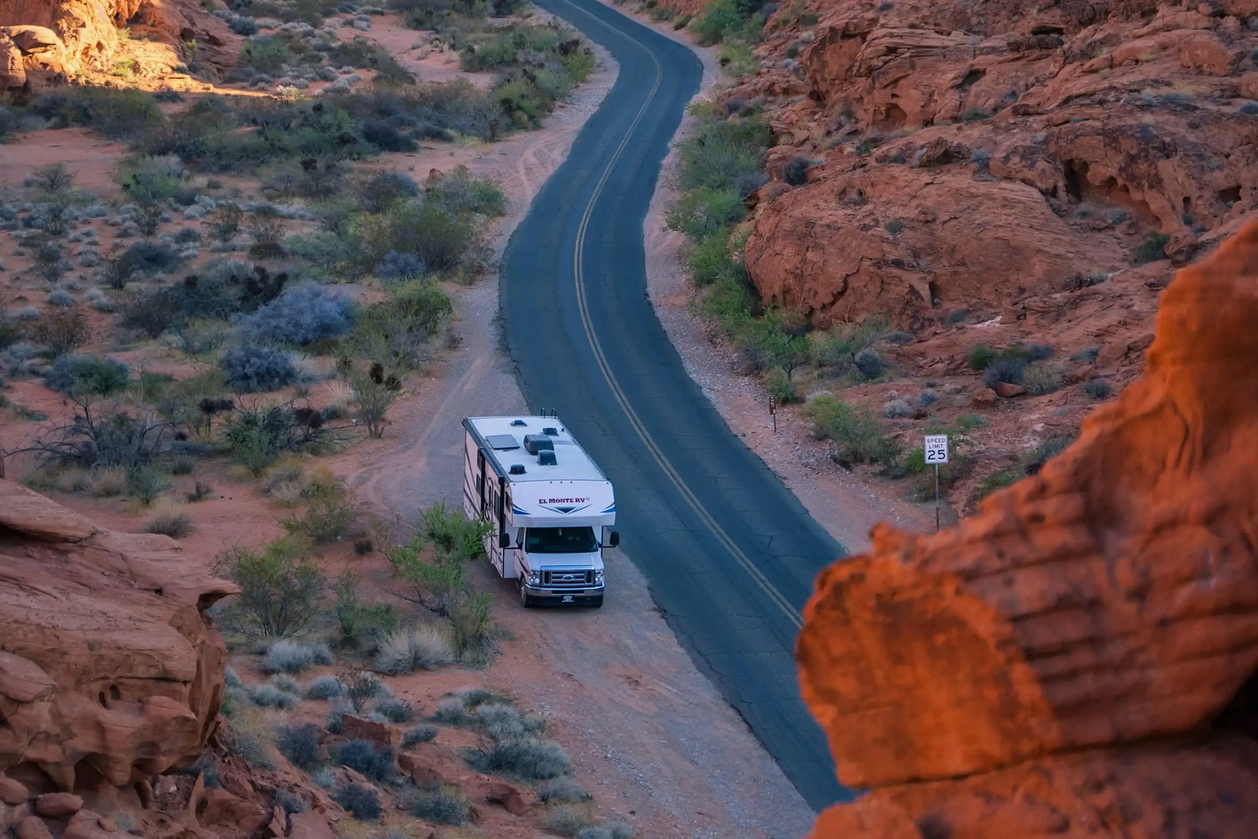 Ein Camper steht zwischen hohen roten Felsen im Red Rock Canyon.