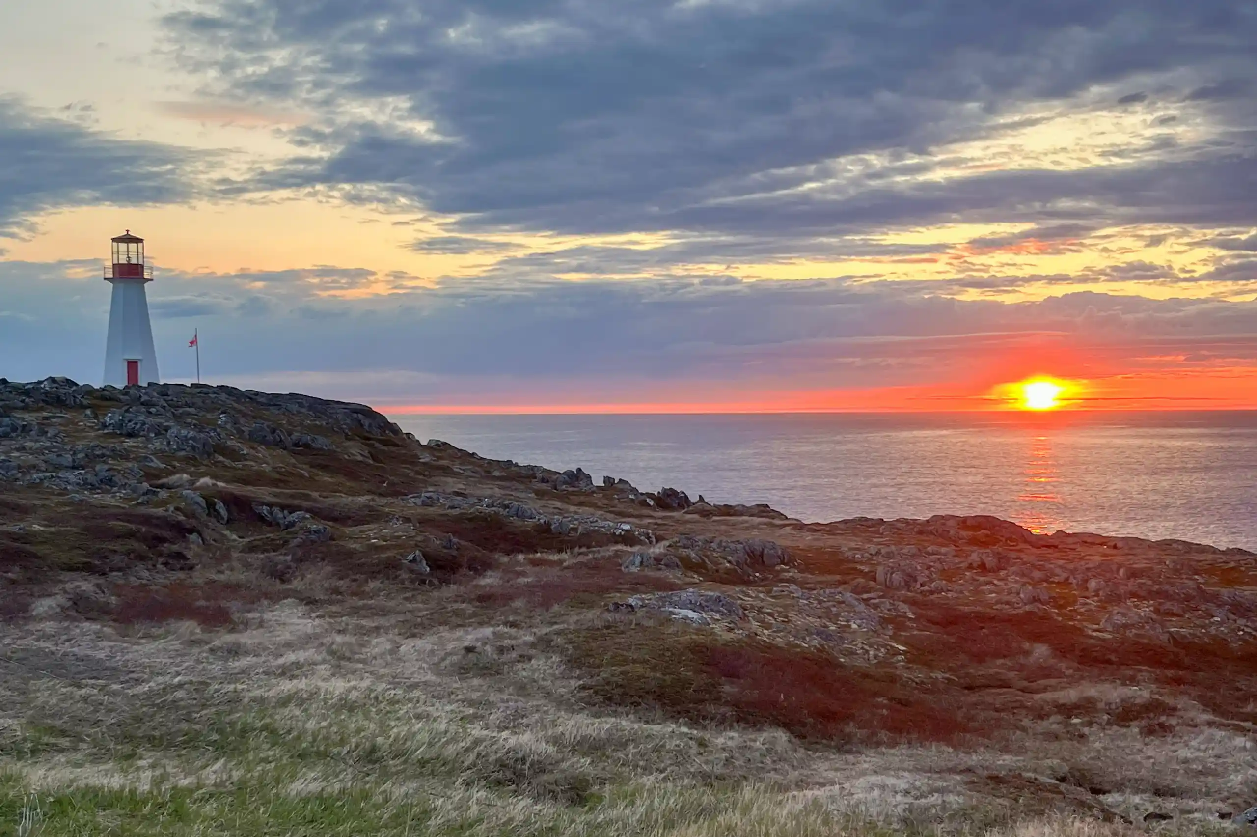 Leuchtturm und Sonnenuntergang auf dem Wasser