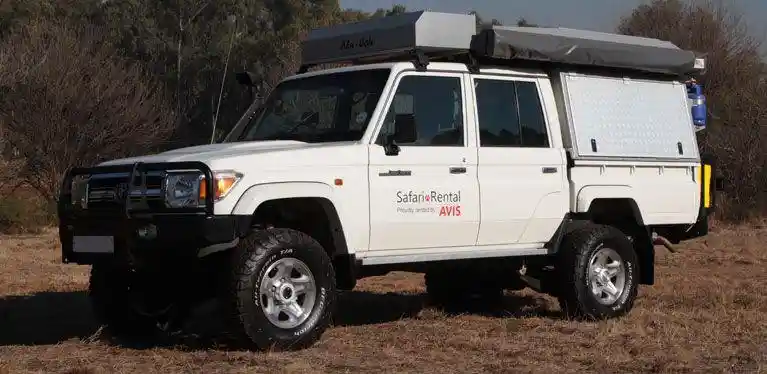 Ein Avis Camper steht auf sandigem Boden