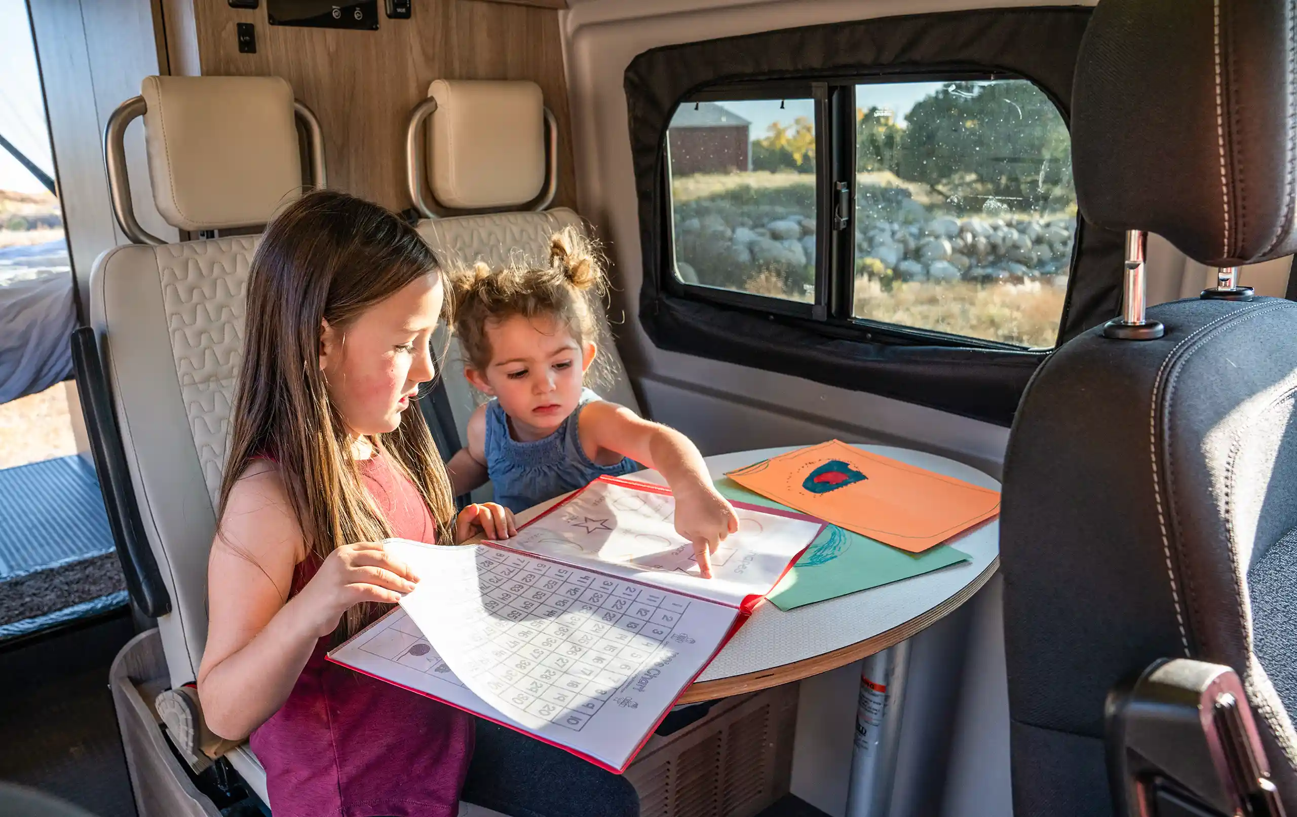 Zwei Kinder sitzen im Wohnmobil.