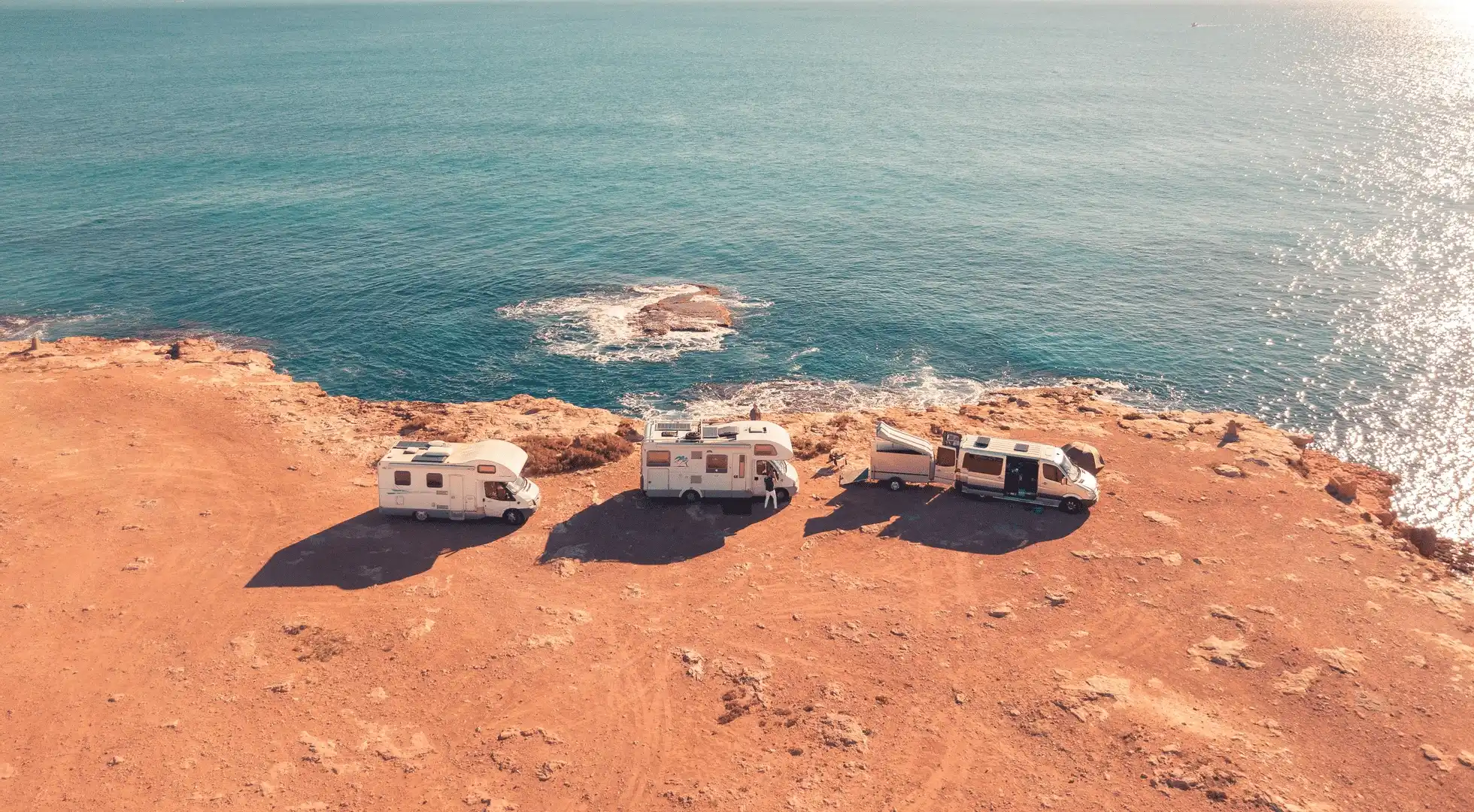 Three motorhomes pause on the coast in Spain