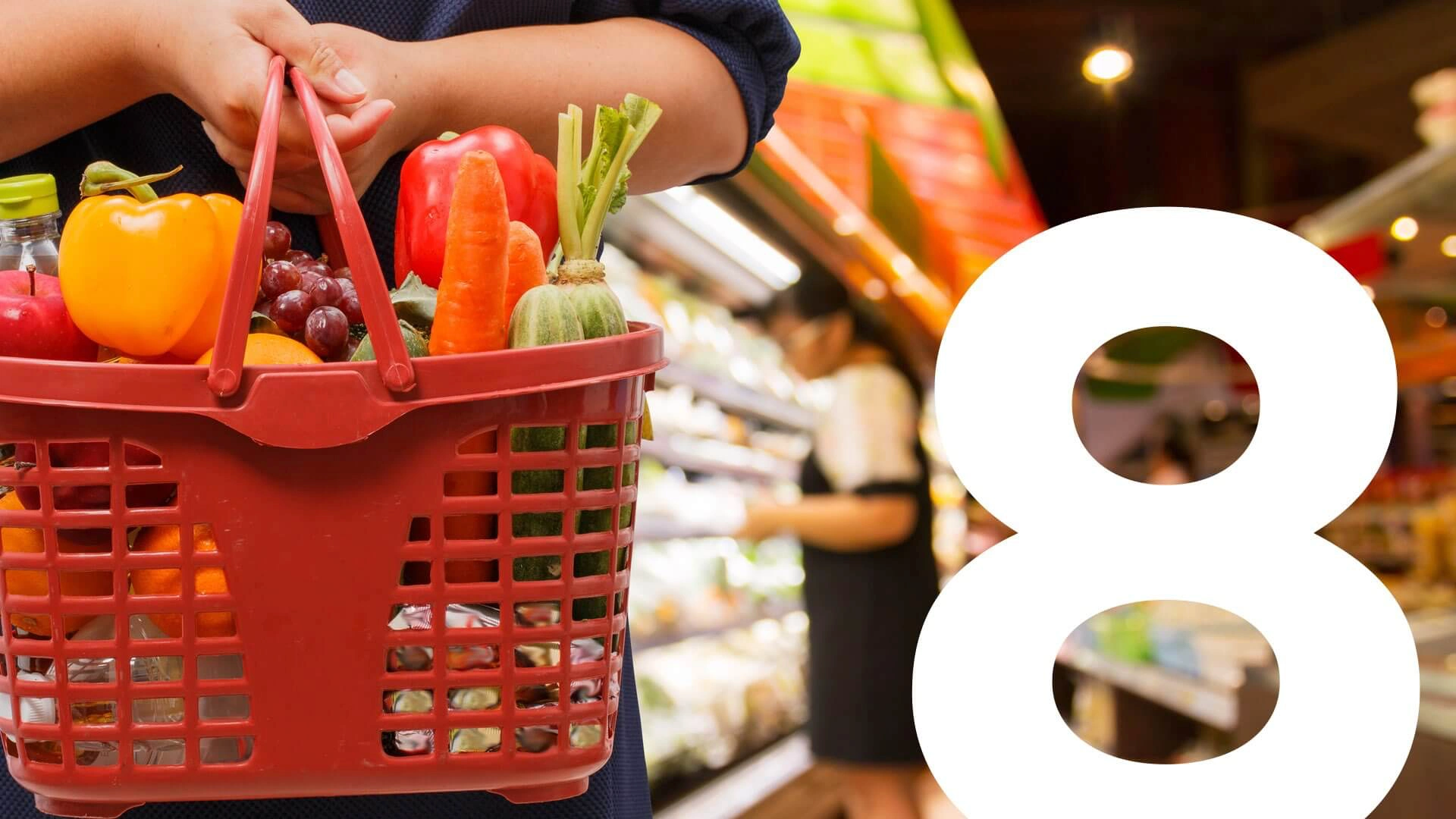 Woman holding full shopping basket in supermarket