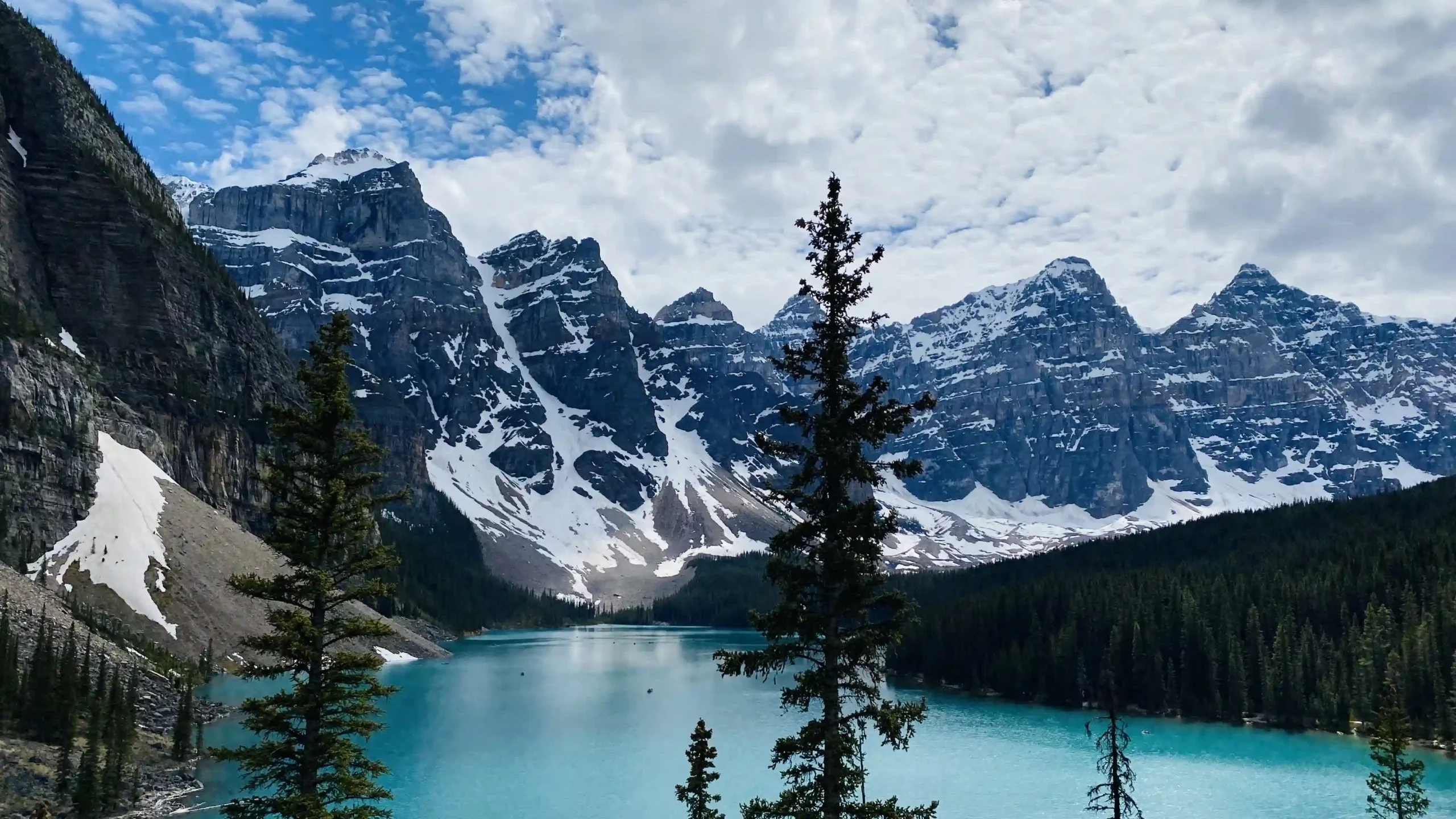 A vibrant turquoise mountain lake framed by a mountain range.