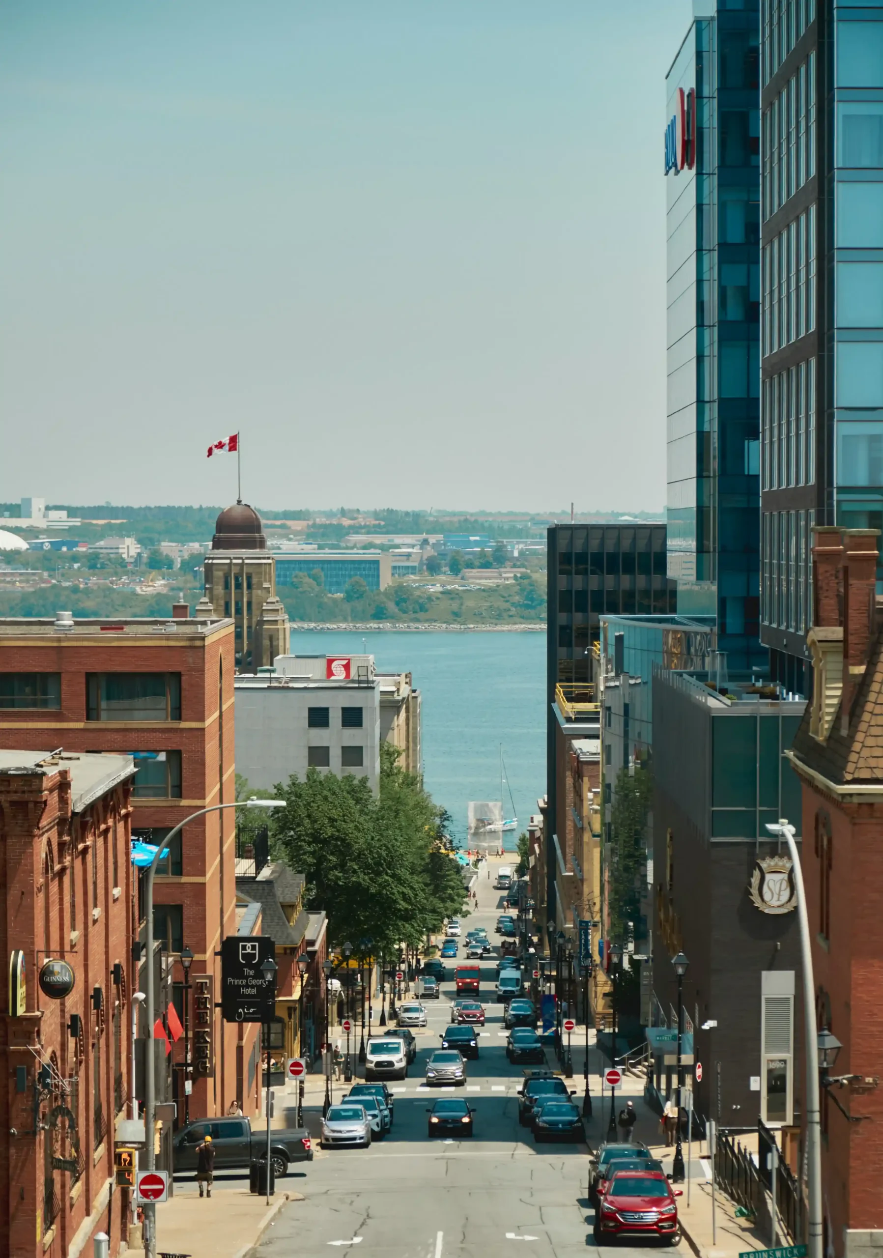Looking down a steep street in downtown Halifax, Nova Scotia, towards the blue water of the harbour.