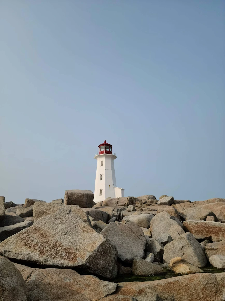 A classic white lighthouse with a red lantern.