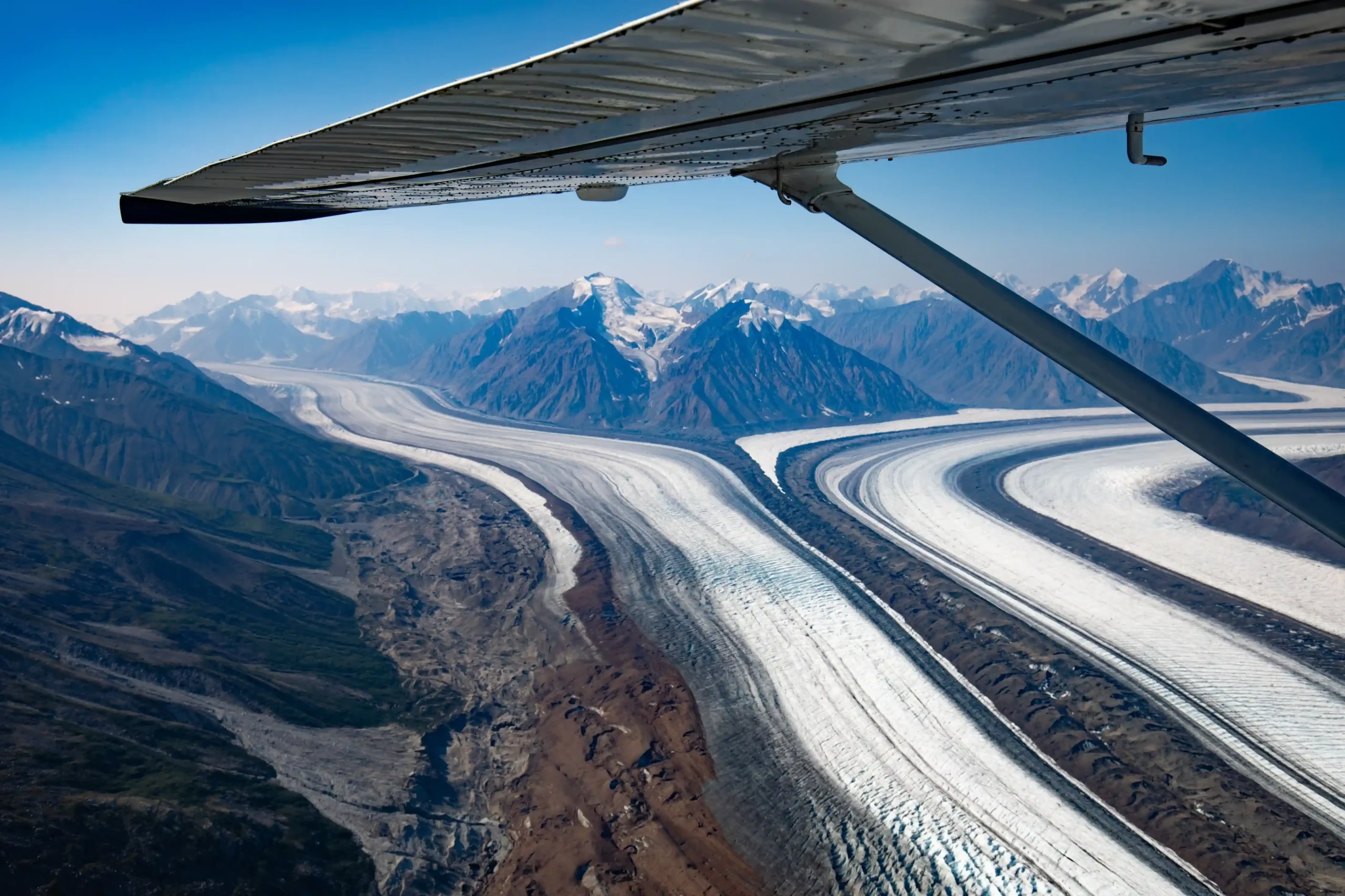 An aerial view from a small plane looking down at the massive Kaskawulsh Glacier and the peaks of the Saint Elias Range.