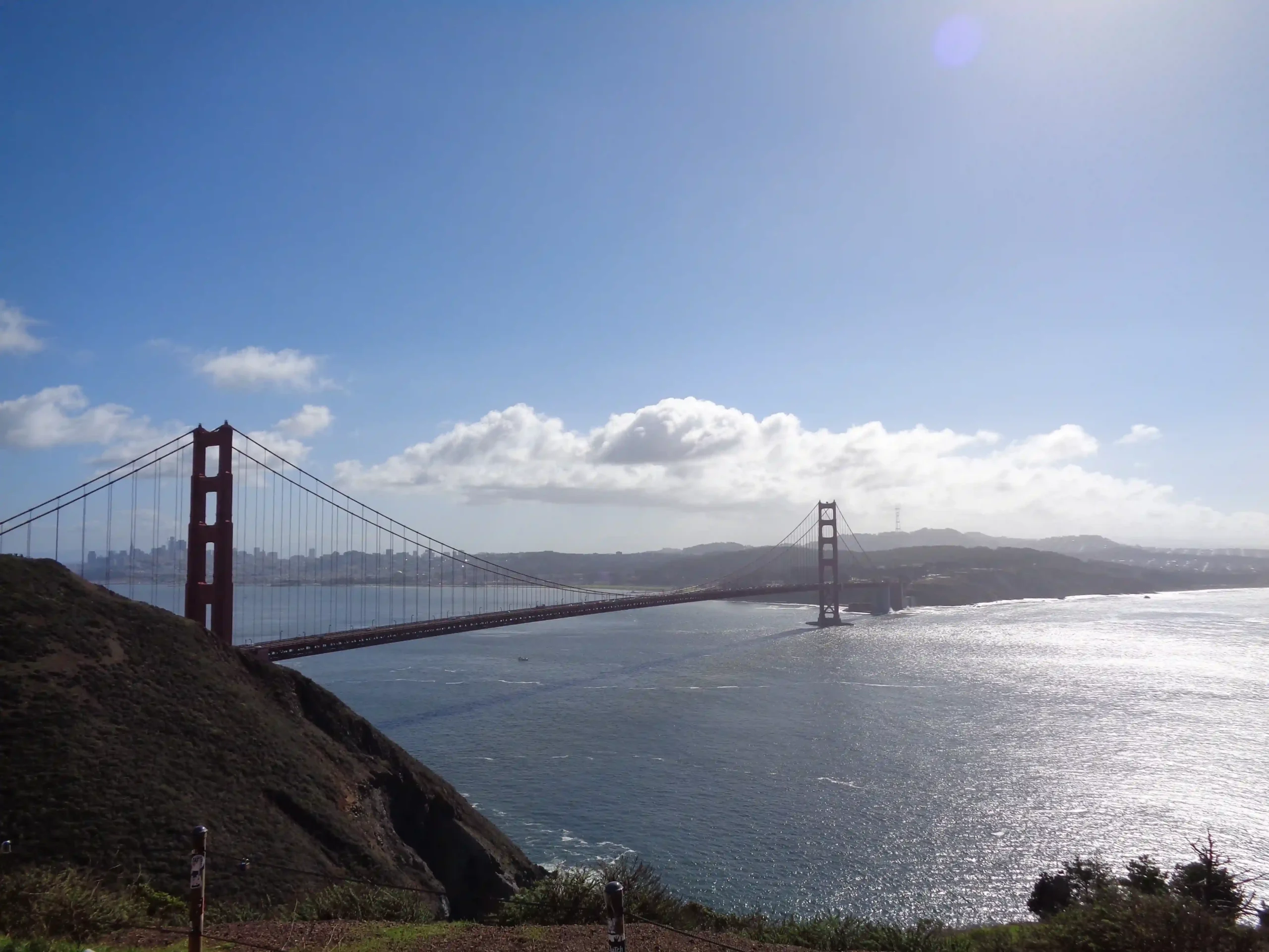 View of the Golden Gate Bridge, with the San Francisco city skyline in the distance.