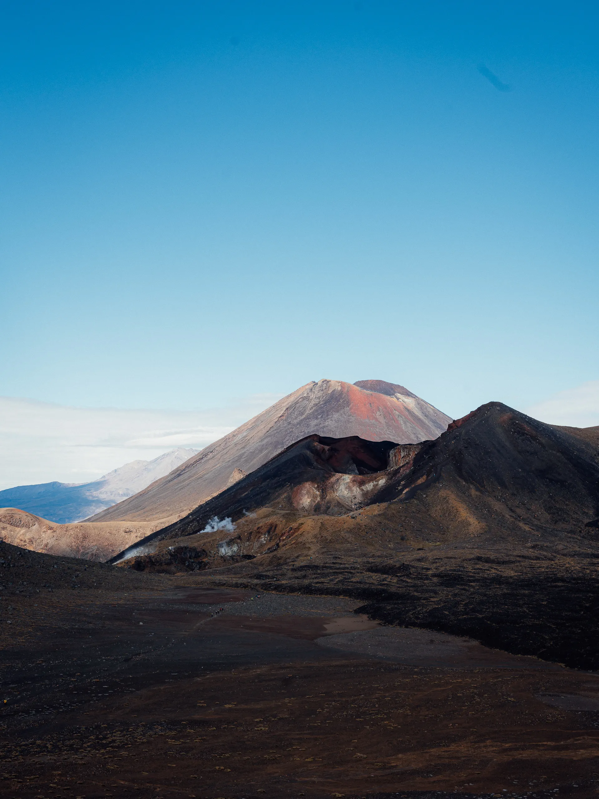 A volcanic landscape featuring a dark red and black crater.