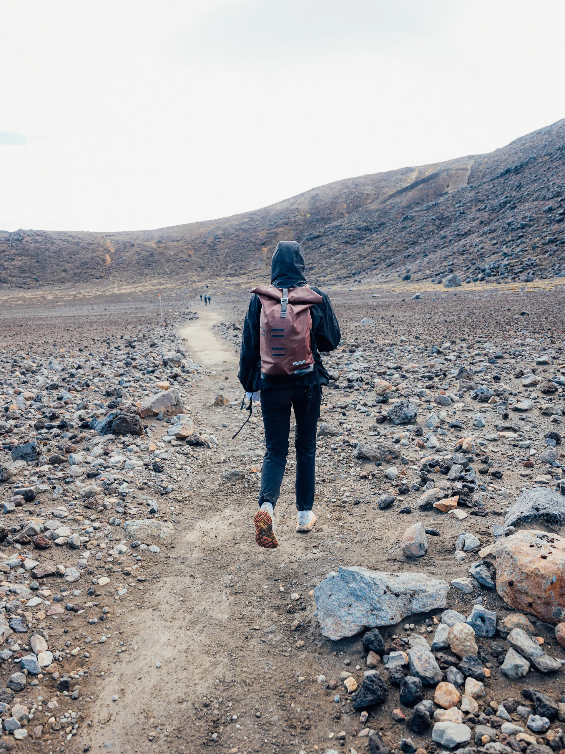 Person hiking in volcanic landscape.