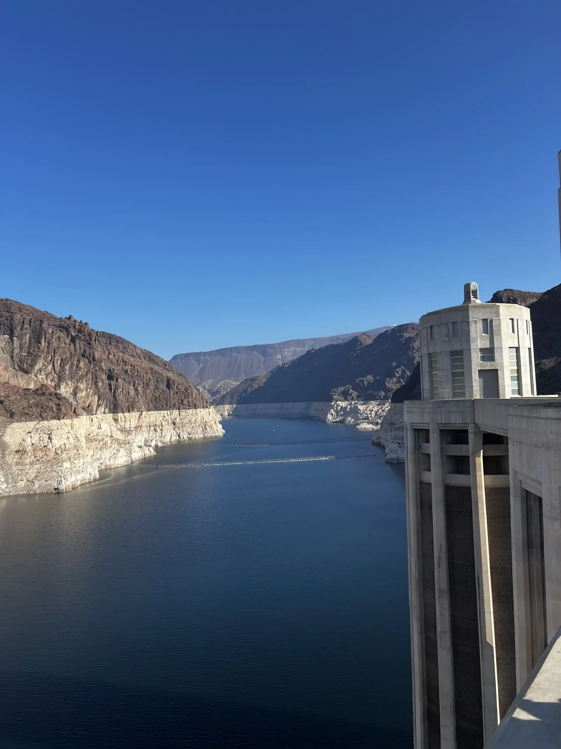 A view of Lake Mead from Hoover Dam. Showing a tower in the foreground on the right, surrounded by the deep blue water.