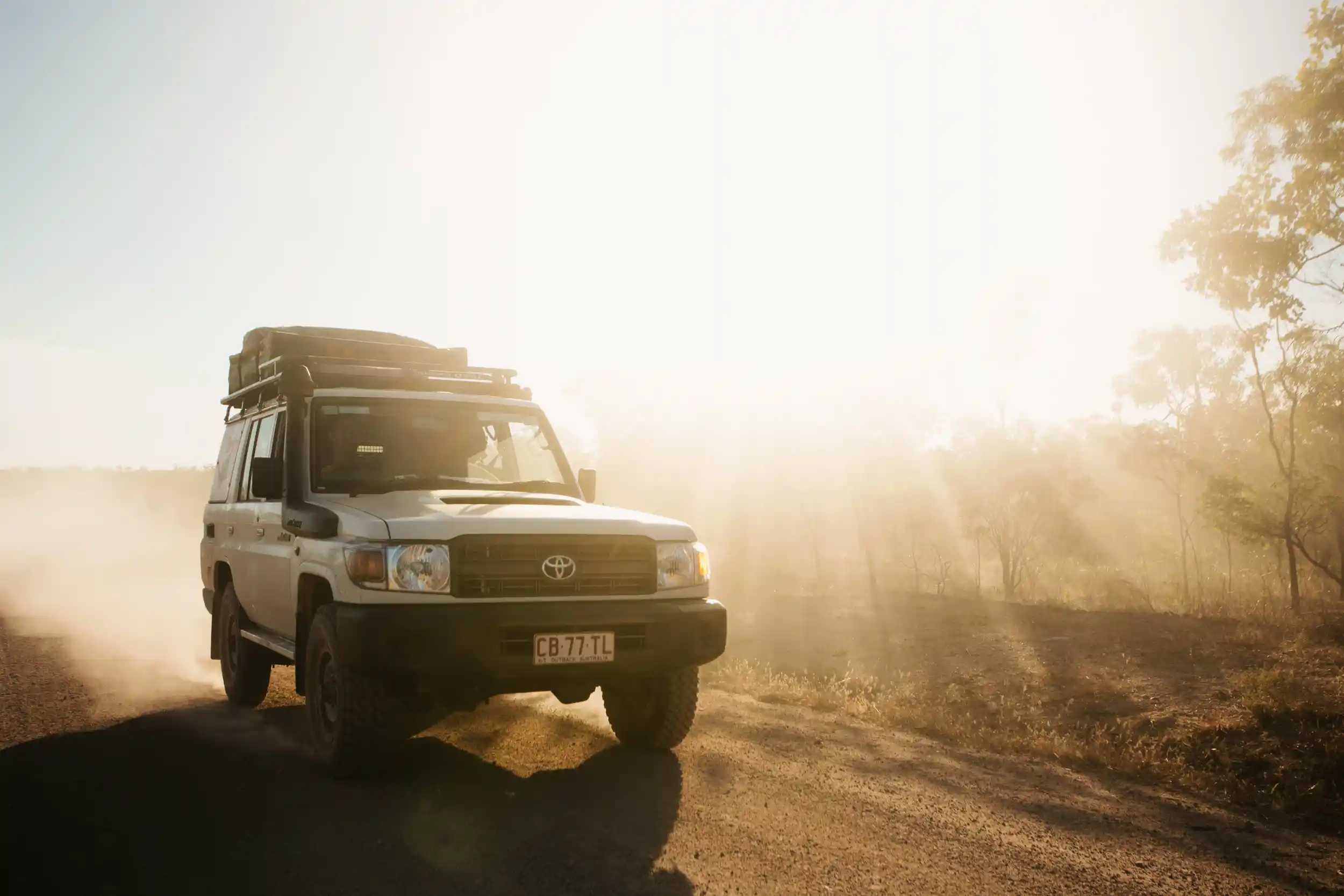 Une jeep Britz roule en Australie au soleil sur une piste non goudronnée.